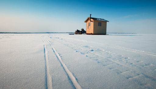 Ice fishing hut on frozen lake