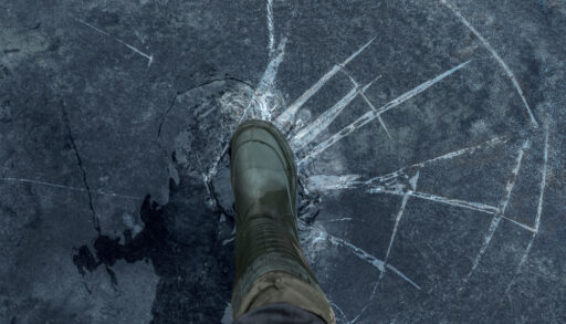Foot pushing on broken frozen lake