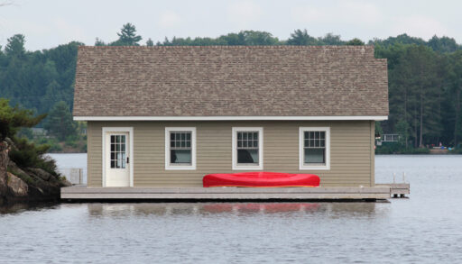 Side view of a boathouse with a red canoe.