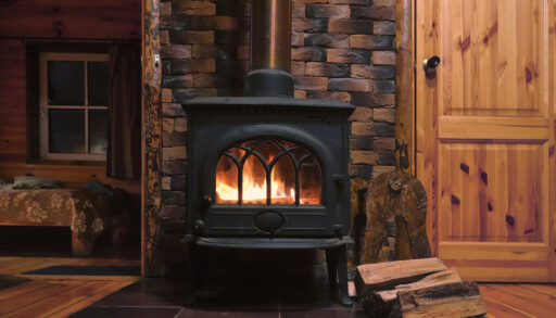 Wood burning fireplace inside cozy wooden cottage
