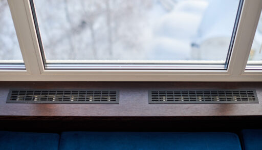 Overhead view of a baseboard heater underneath a window.