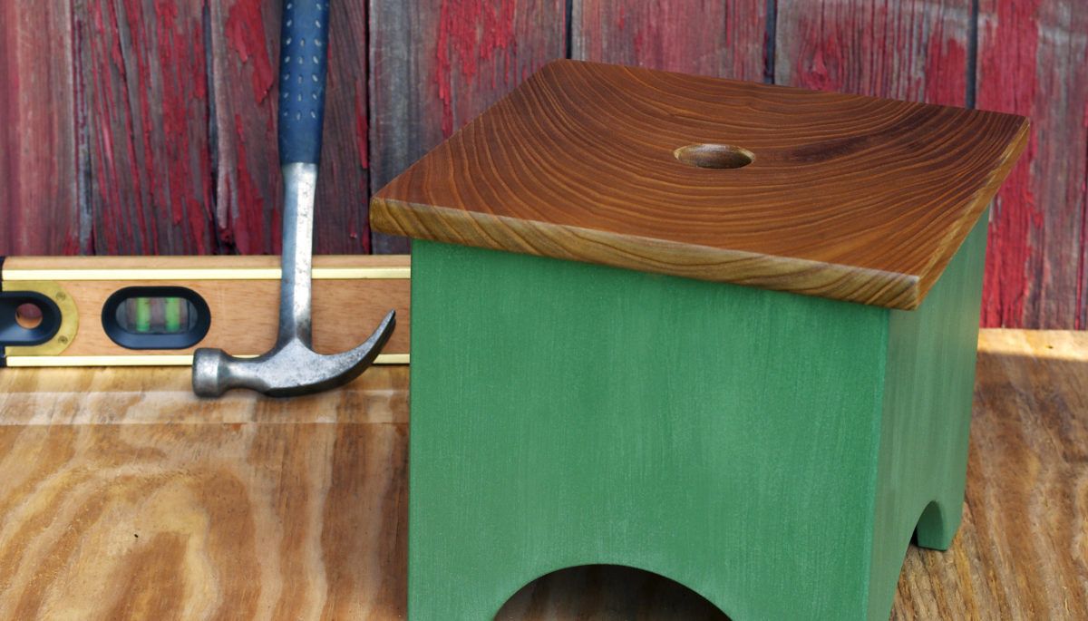 Green step stool with hammer behind it