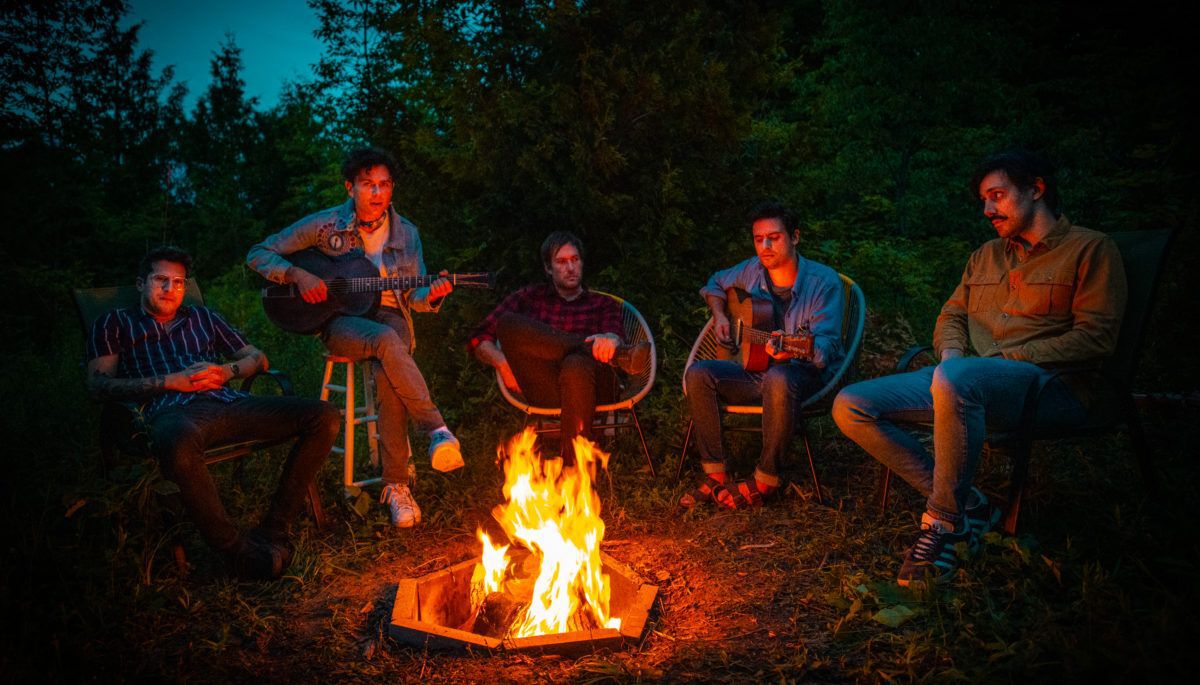 arkells the band sitting around a campfire at night, album promo shot