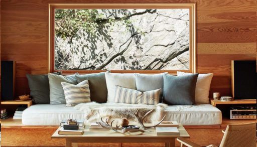 a cottage living room with a window that frames a granite rockface