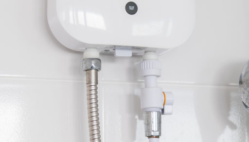 A tankless hot water heater mounted to a white wall