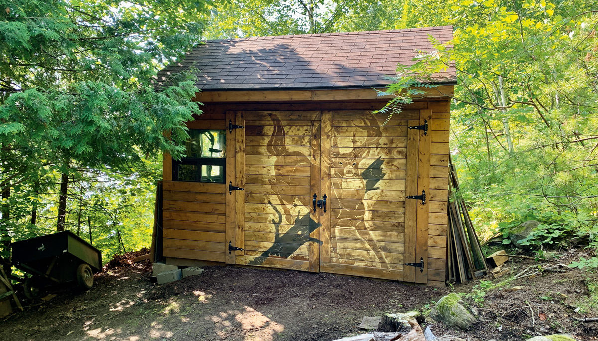 photo of an ATV shed with a deer carved onto the doors