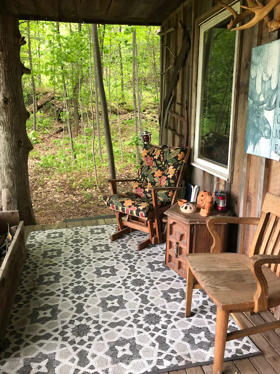 Two chairs on porch of cabin in woods