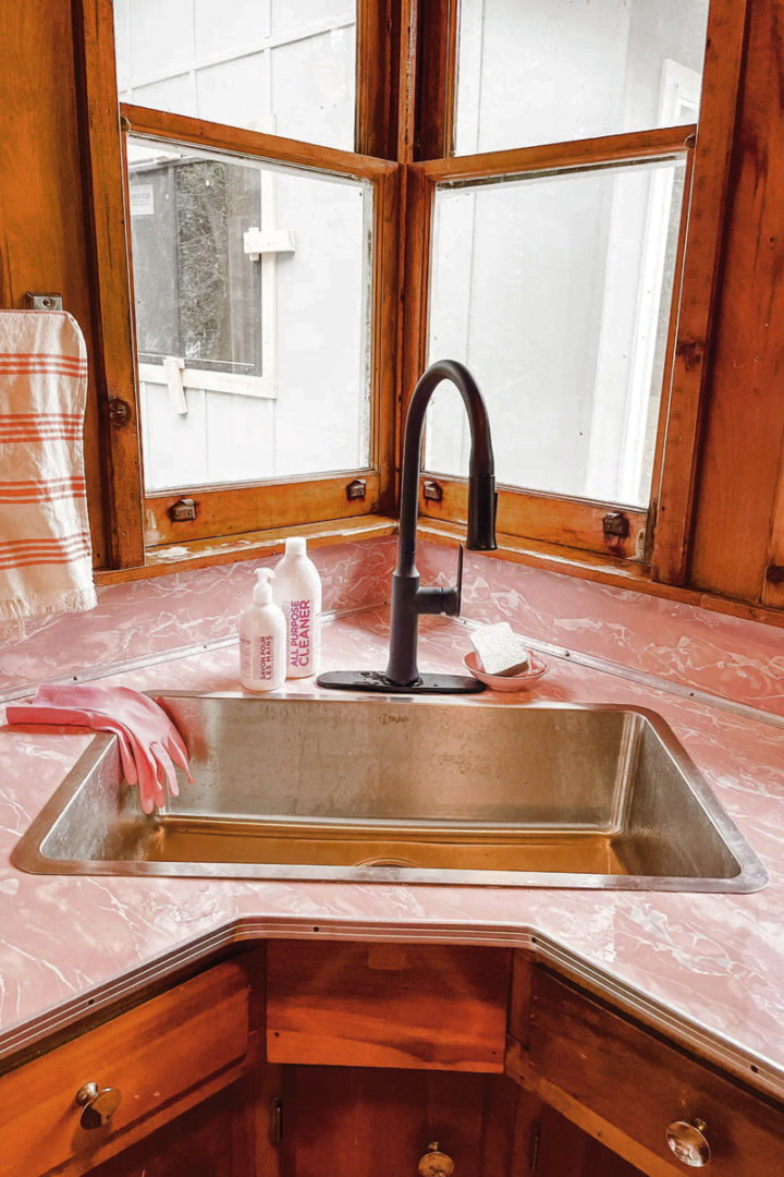 a close-up of the kitchen sink and the pink formica countertop