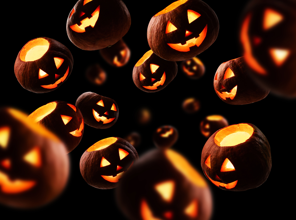 Several glowing, carved pumpkins against a dark background