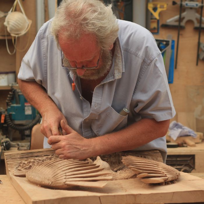 A man carving an osprey into wood
