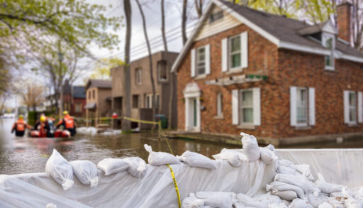 flooded house with sandbags in front of it