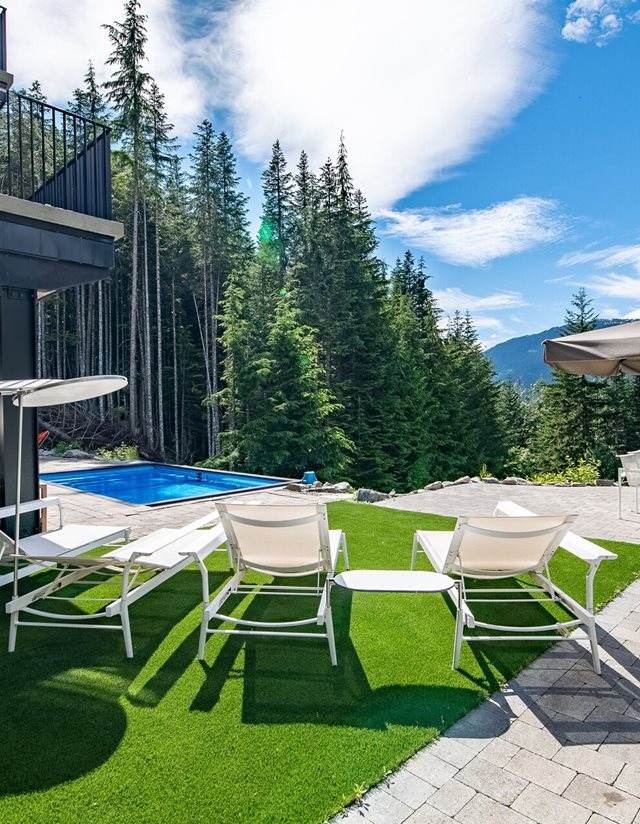 backyard featuring lounge chairs, a grass patch, and the hot tub
