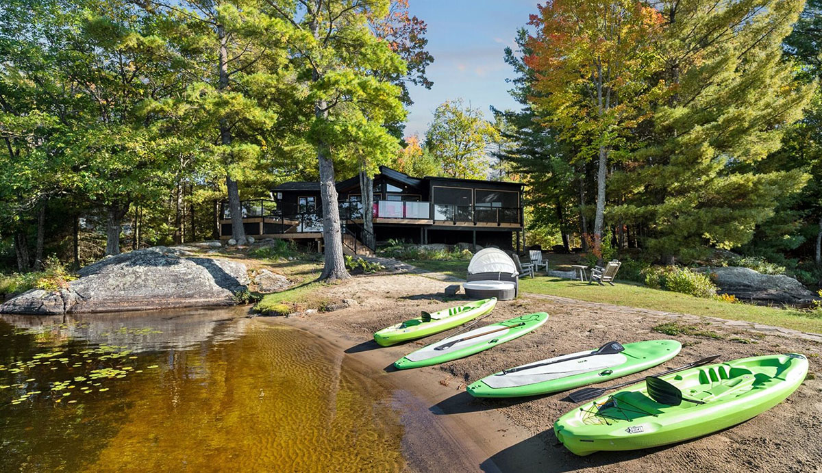waterfront view of cottage featuring 4 green kayaks