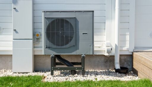 Air source heat pump installed on the exterior of a wooden house