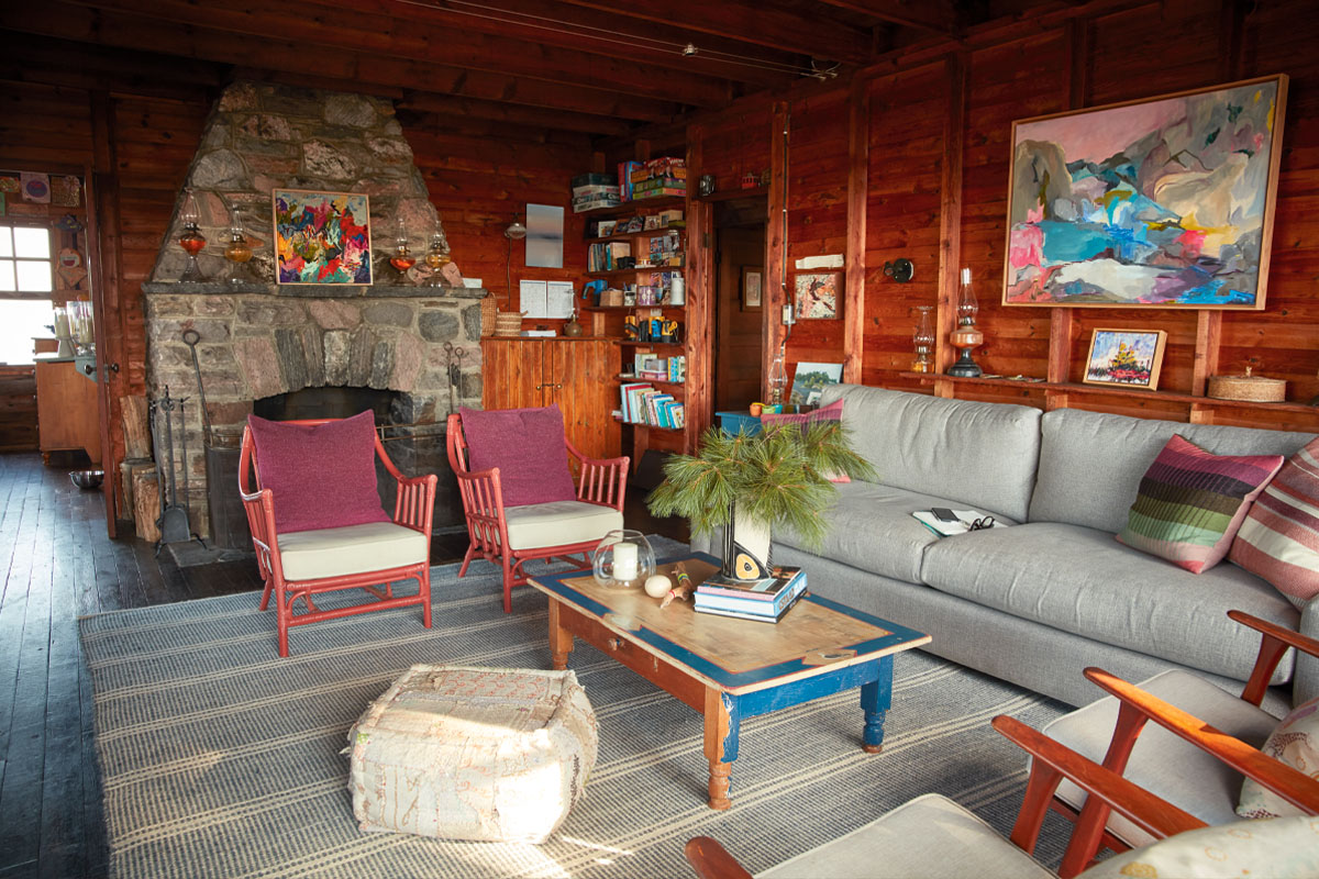 The other side of the living room at Kara McIntosh's Georgian Bay cottage. There's a big stone fireplace and art on the walls