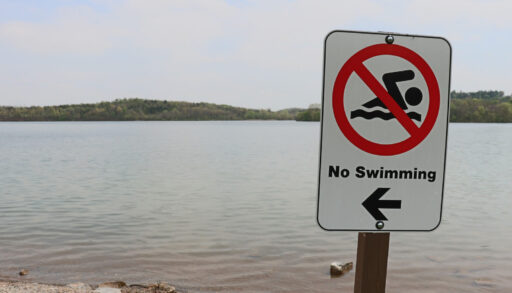 "No swimming" advisory sign posted in font of a beach