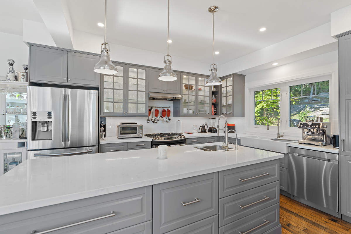 A big, modern kitchen with an island, modern appliances, and light grey cabinets.