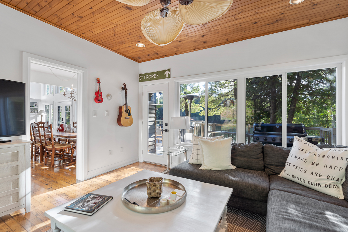 A big, bright sunroom with a wood-panelled ceiling and plenty of seating.