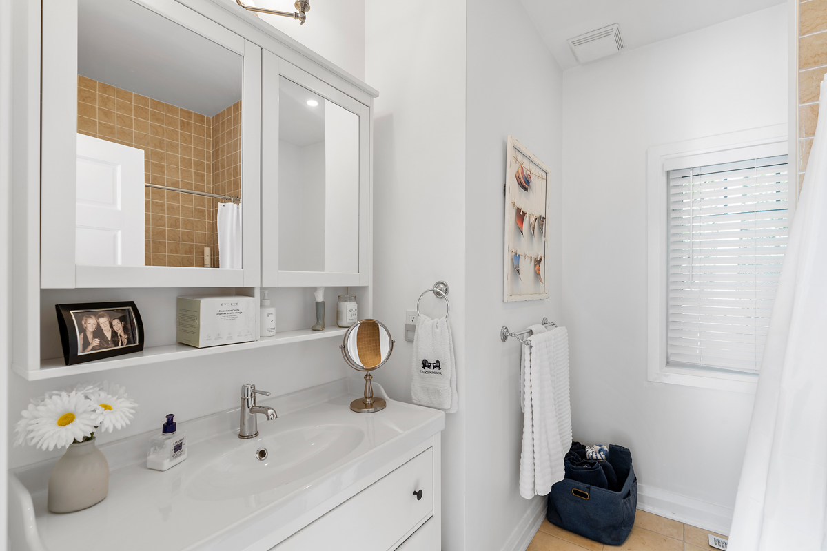 A white bathroom with a sink, a toilet, and a shower-tub combo.