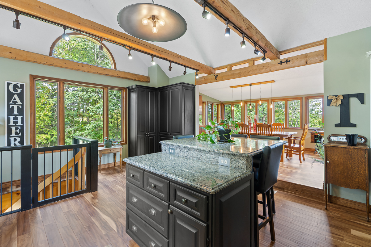 A big, bright kitchen area with an island, that flows into a bright dining area.