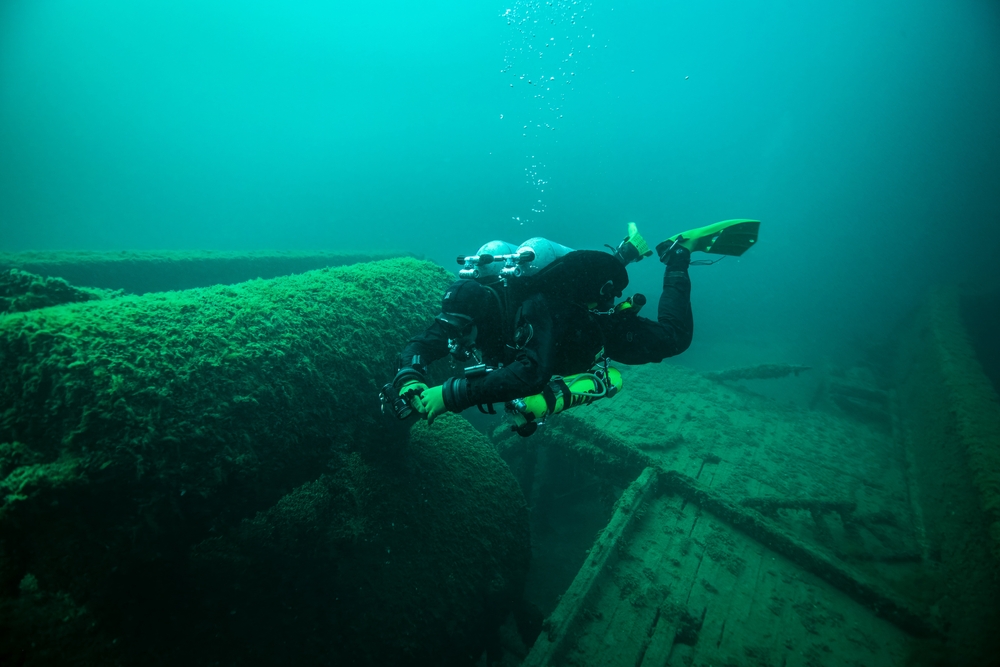 diver underwater looking at a shipwreck