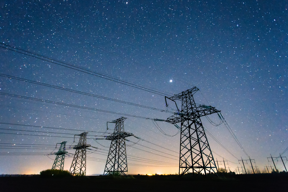 High-voltage power lines on the background of the starry sky