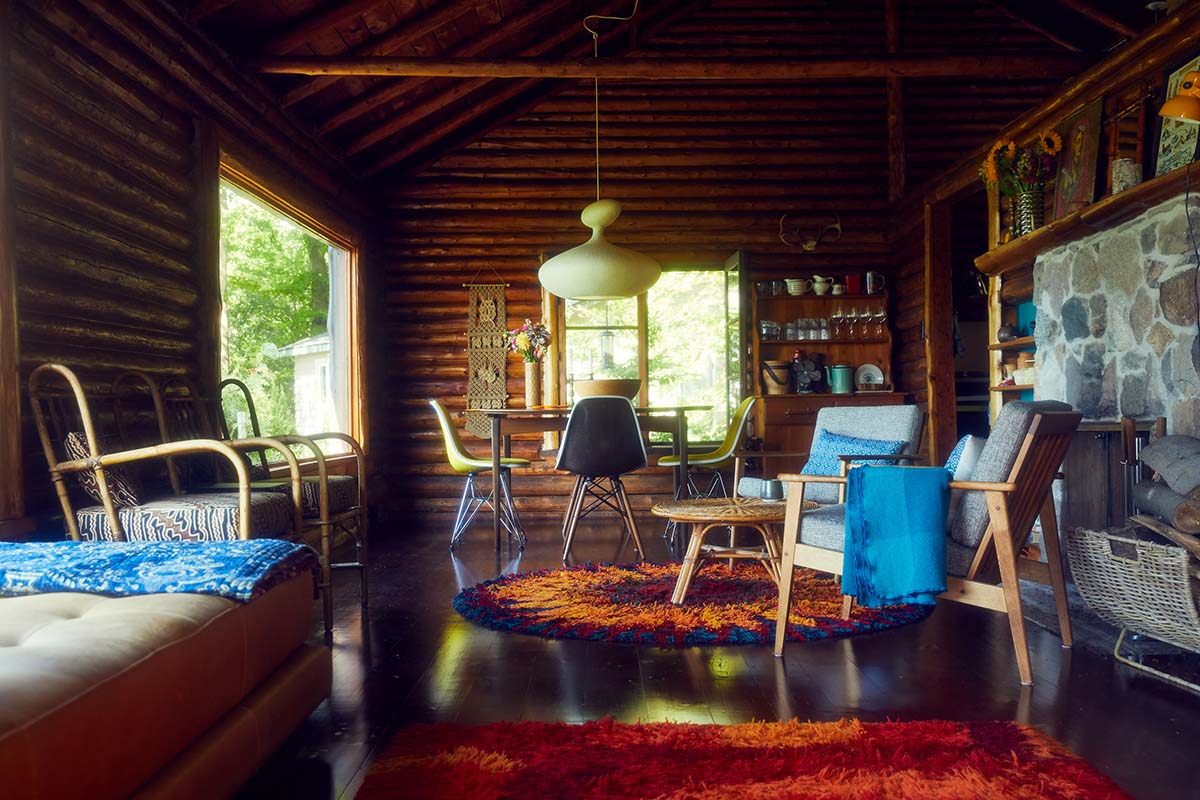 an interior photo of a cottage living room with log walls and vibrant decor