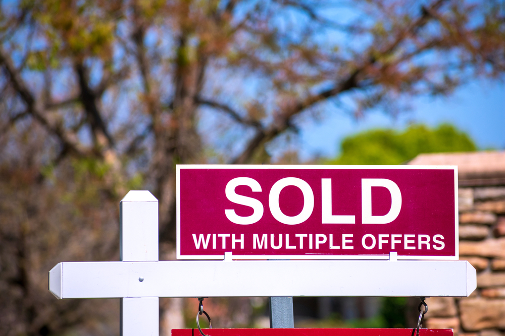 sold sign with a note that sold with multiple offers
