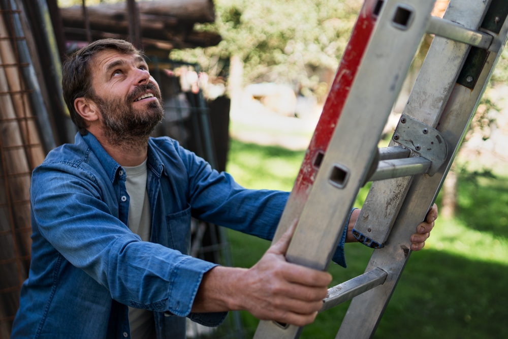 A man about to climb a metal ladder