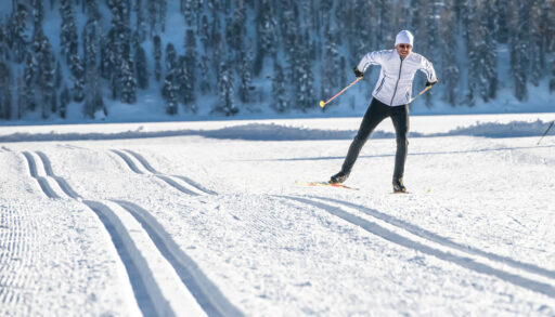 A man practicing skate skiing on flat, snowy ground