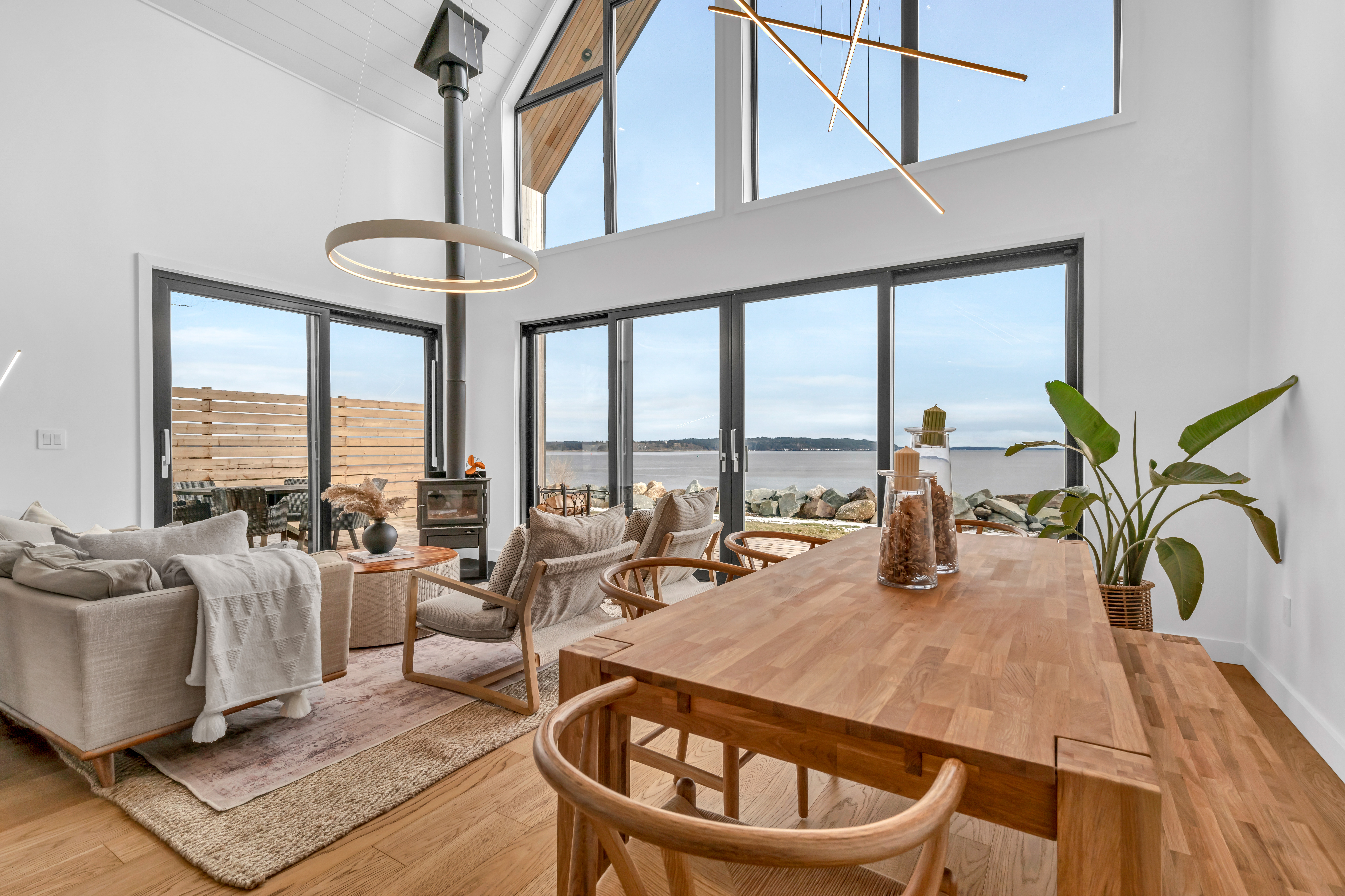 A big open-concept living and dining area. Floor-to-ceiling windows look out to the ocean and let in lots of natural light.