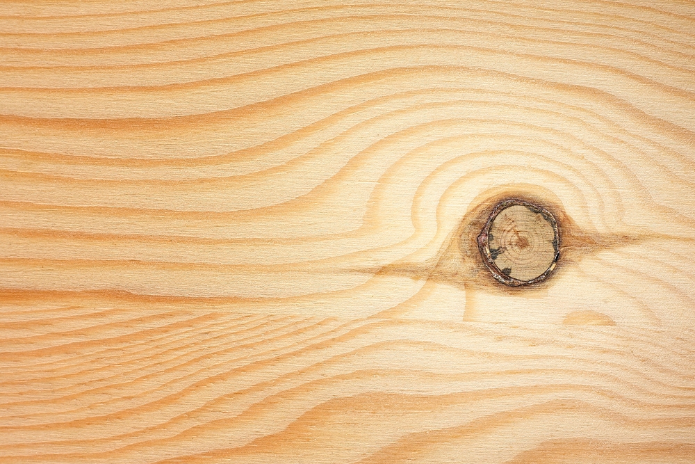 A wood board with a knot in it