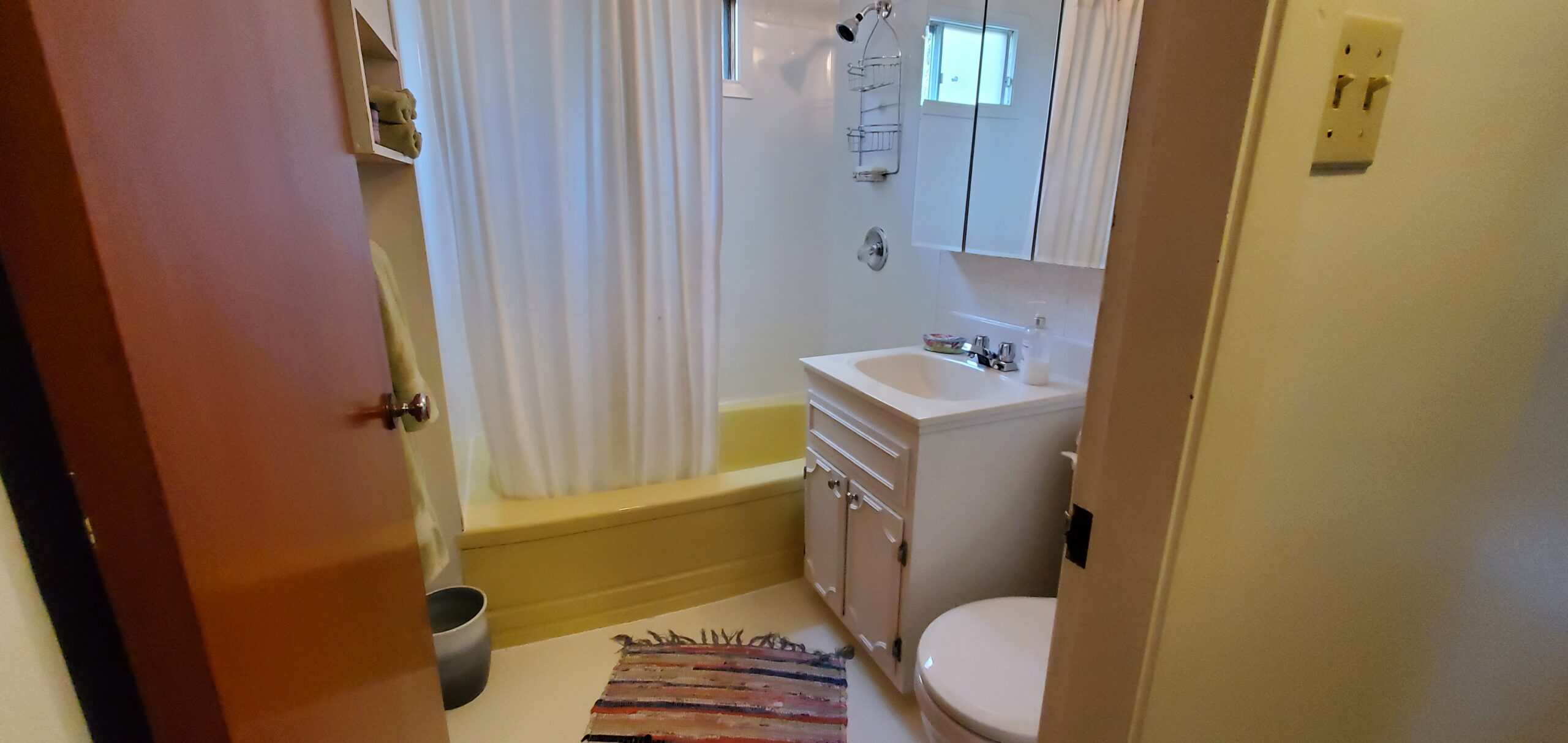 A bathroom with a toilet, a sink, and a shower-tub combo.