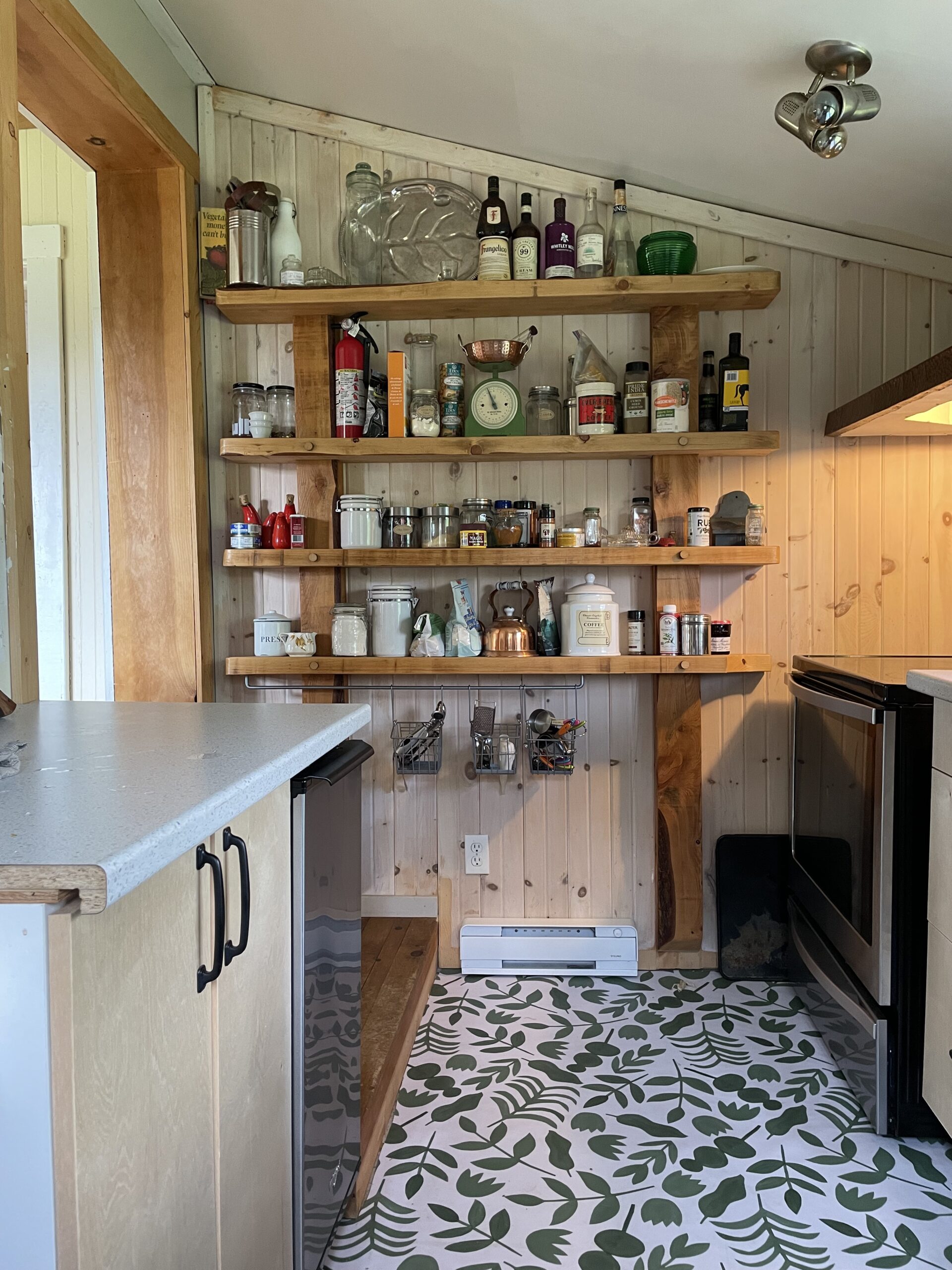 a kitchen with a patterned floor and shelving