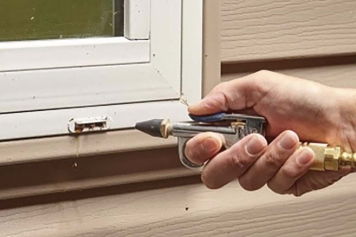 A hand using a tool to make a window adjustment